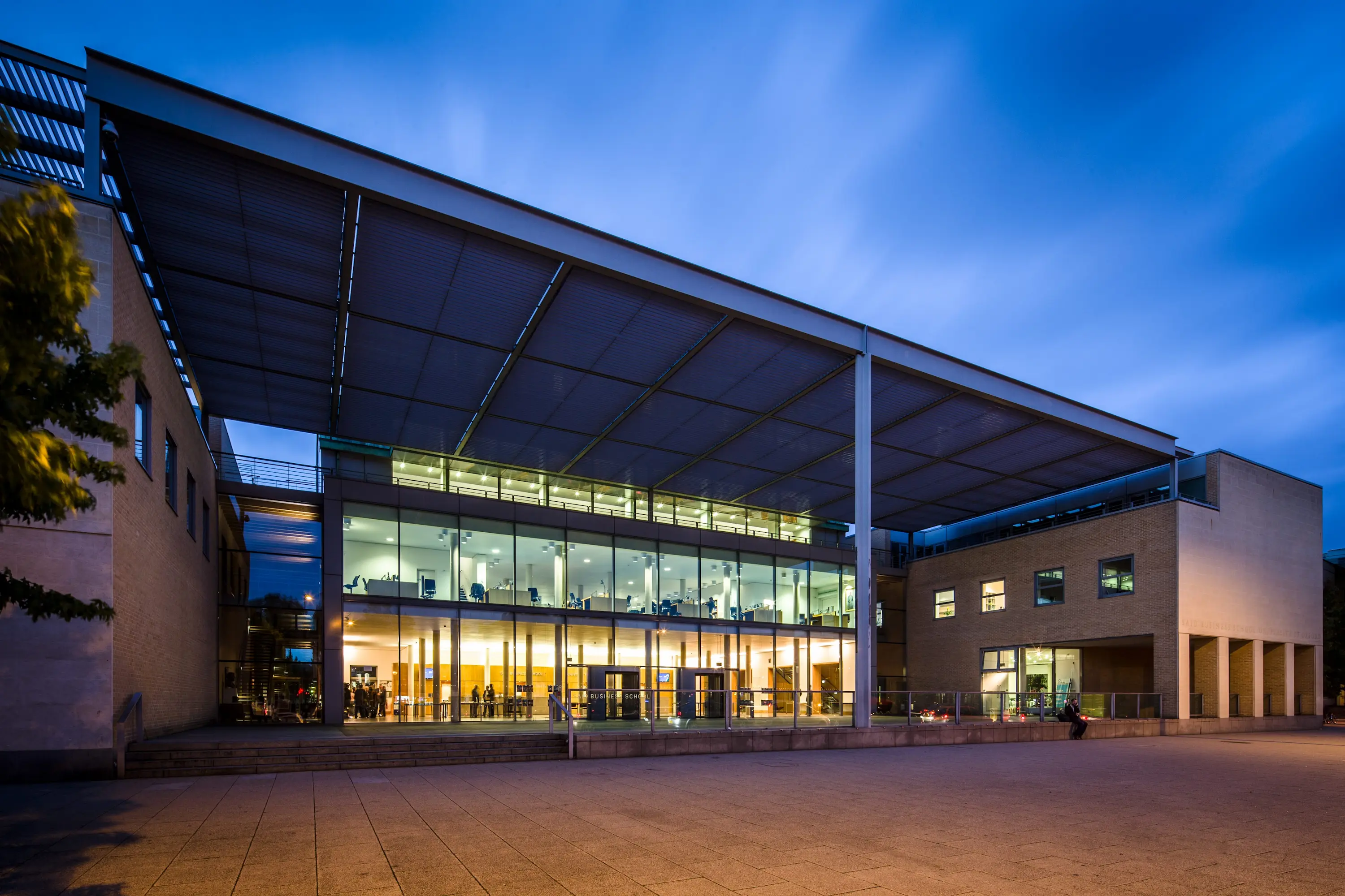 A striking architectural photograph of a modern educational or commercial building at dusk or twilight.